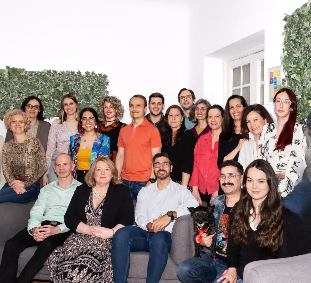 Group photo of LAE Madrid’s diverse teaching and administrative team, smiling together with a dog in the front row