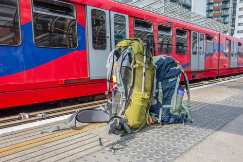 Two travel backpacks on a train platform in Spain, promoting sustainable and responsible travel.