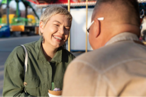 Una pareja de mediana edad sentada a la mesa en un ambiente cálido y acogedor, sonriendo y manteniendo una conversación auténtica y relajada.