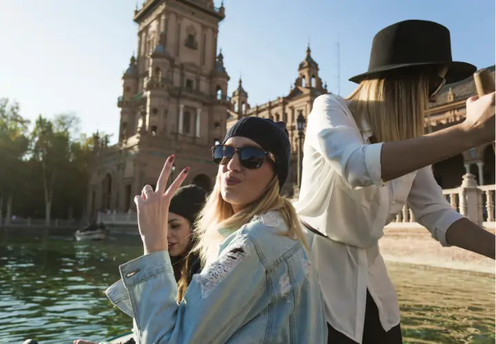 A group of young women enjoying a sunny afternoon by the water in a historic Spanish plaza, capturing the vibrant "Rhythm of Life" and outdoor social energy of Madrid in spring.