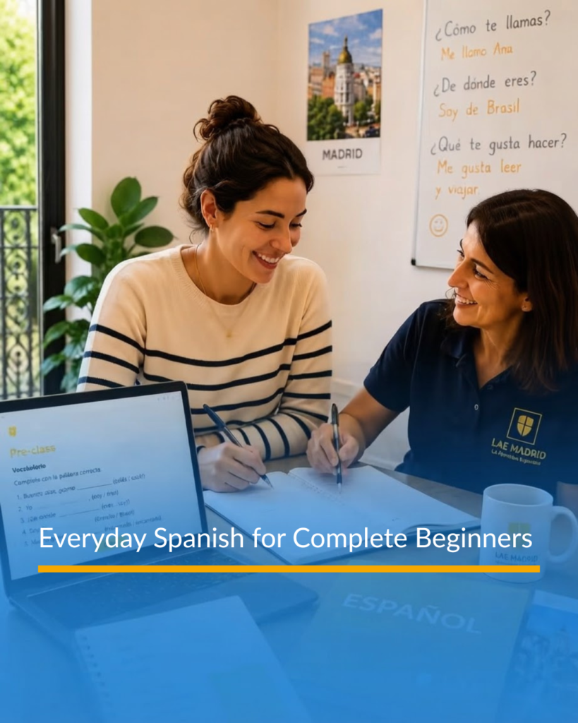 A student working alongside an LAE Madrid Spanish teacher with a laptop showing pre-class vocabulary exercises next to a whiteboard with introductory phrases.