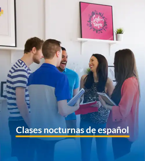 Adult learners attending an evening Spanish class at LAE Madrid in a cozy classroom setting.
