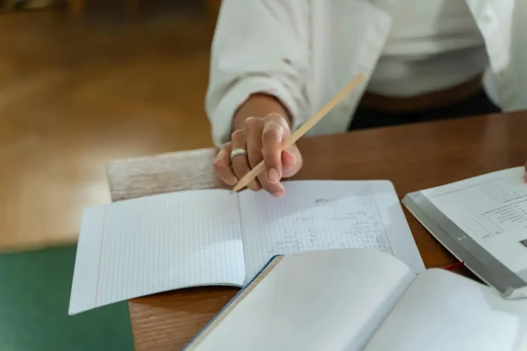 Student studying with notebook and exam materials for Spanish DELE and SIELE preparation