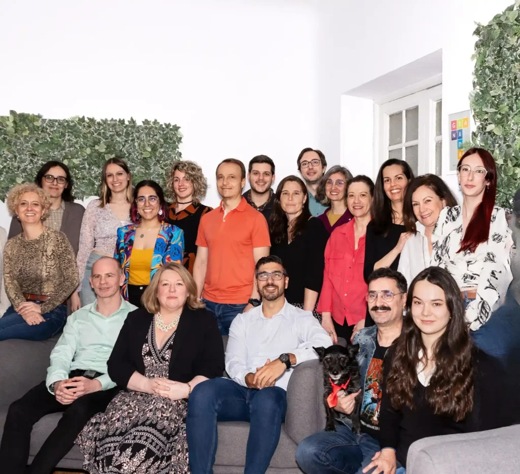 Group photo of LAE Madrid’s diverse teaching and administrative team, smiling together with a dog in the front row