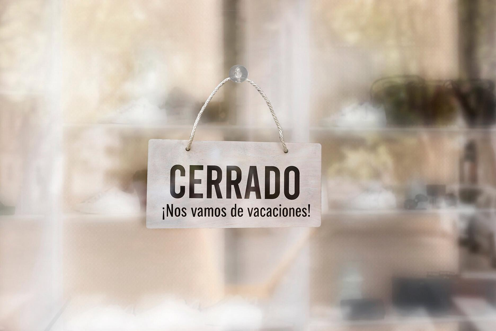 Cartel de cerrado por vacaciones en la puerta de un negocio en Madrid