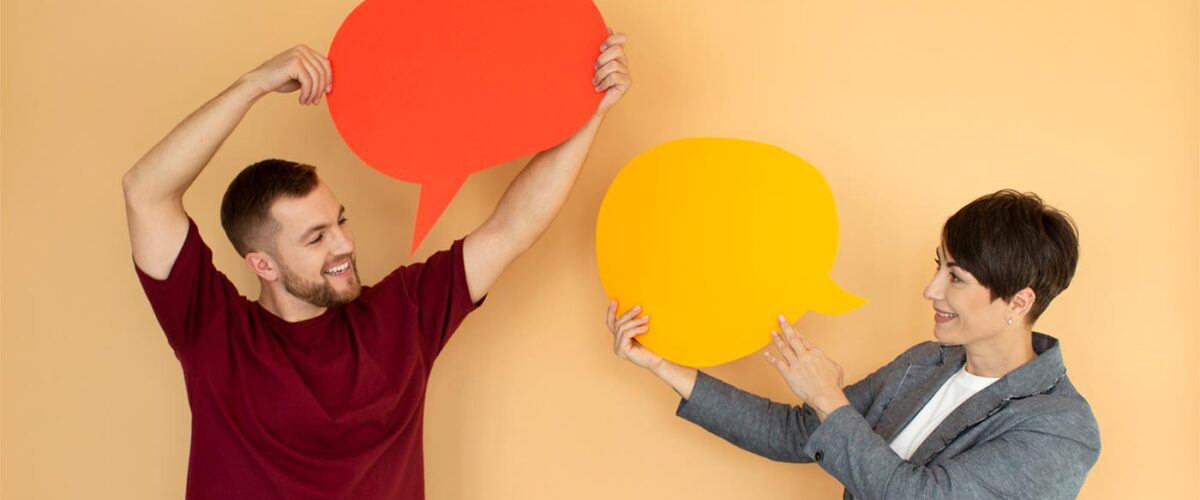 Two people holding speech bubbles representing language learning and communication