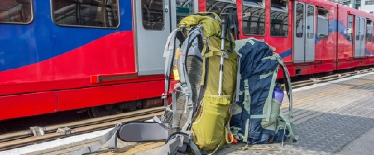 Two travel backpacks on a train platform in Spain, promoting sustainable and responsible travel.