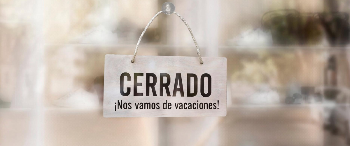 Cartel de cerrado por vacaciones en la puerta de un negocio en Madrid